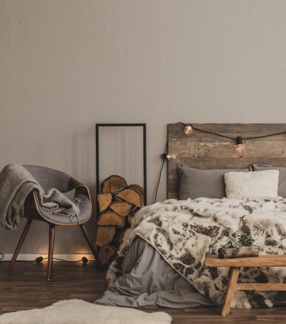 a bed with a blanket and a wooden table in a bedroom