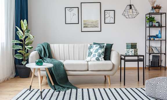 a living room with a white couch and green pillows