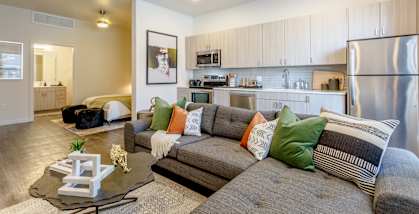 A modern living room with a grey couch and a coffee table.
