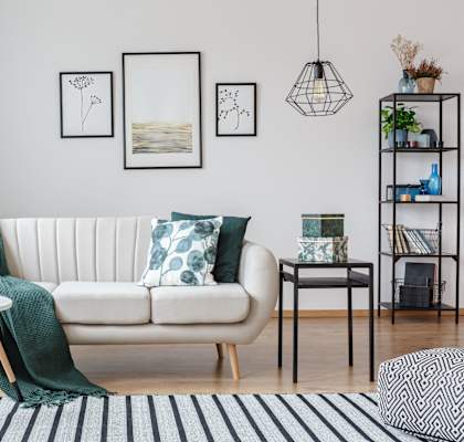 a living room with a white couch and green pillows