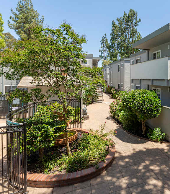 A sign for Lakeshore Apartments is displayed in front of a tree.