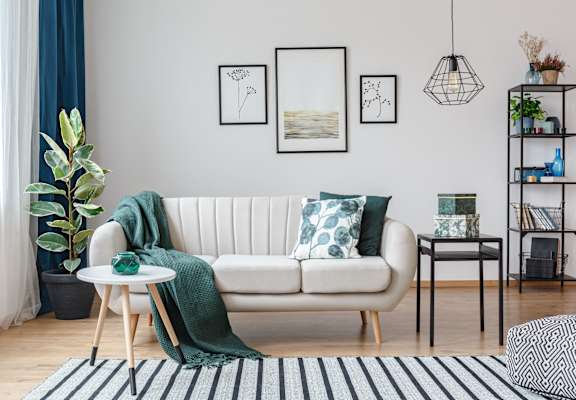 a living room with a white couch and green pillows