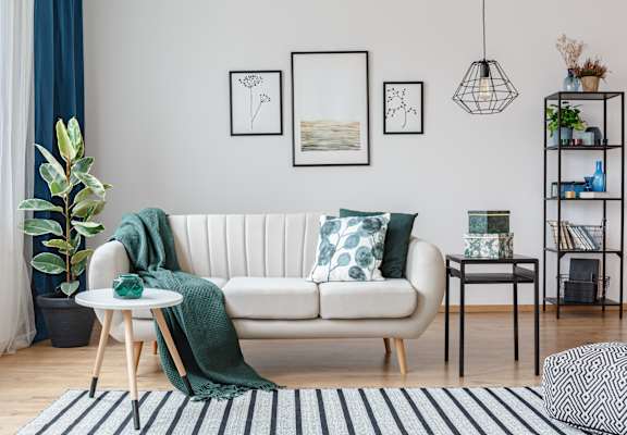 a living room with a white couch and green pillows