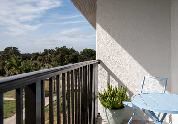 A balcony with a blue chair and table.