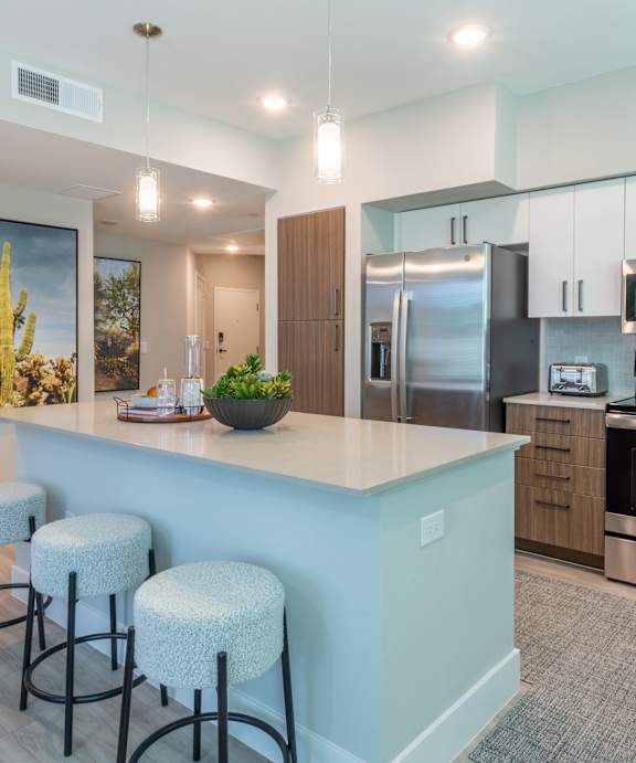 A kitchen with a bar area and stools.