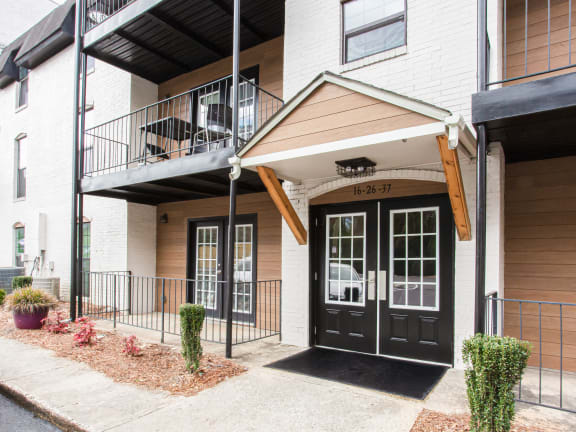 the front entrance of an apartment building with a black door