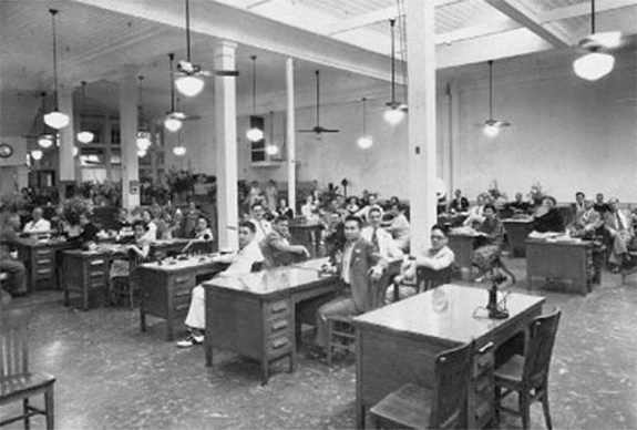 a group of people sitting at tables in an unemployment office