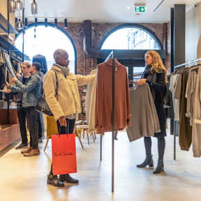 a group of people looking at clothes in a store