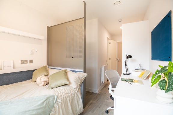 a bedroom with a bed and a desk and a workstation