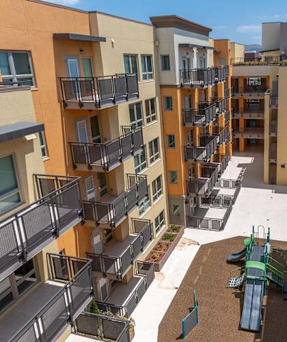 Apartment complex with a playground in the courtyard.