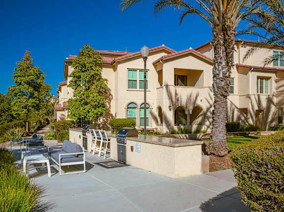 A large house with a patio and a palm tree.