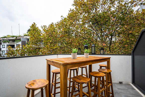 a wooden bar on a roof terrace with stools