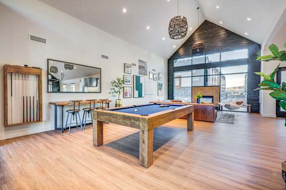 A room with a pool table and a mirror on the wall.