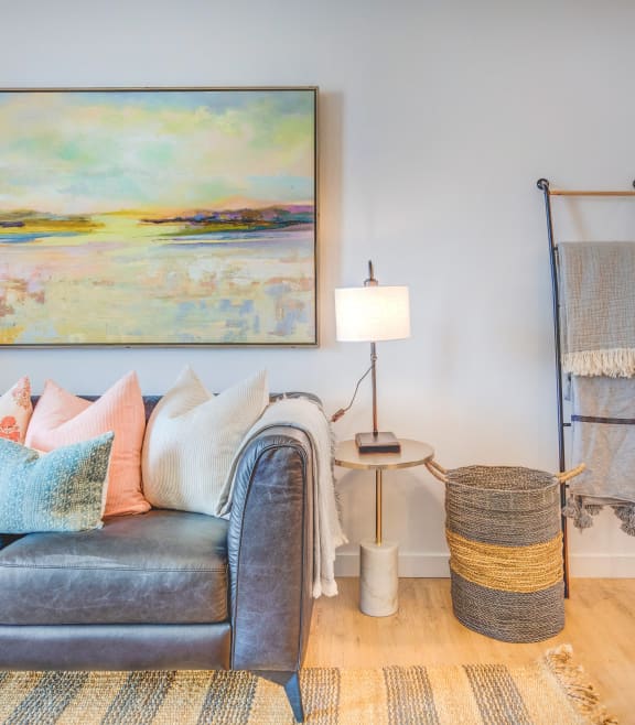 a living room with a couch and a painting on the wall