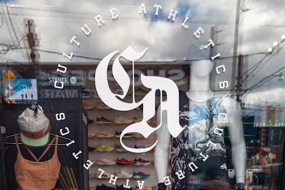 a window display of a clothing store with a white logo