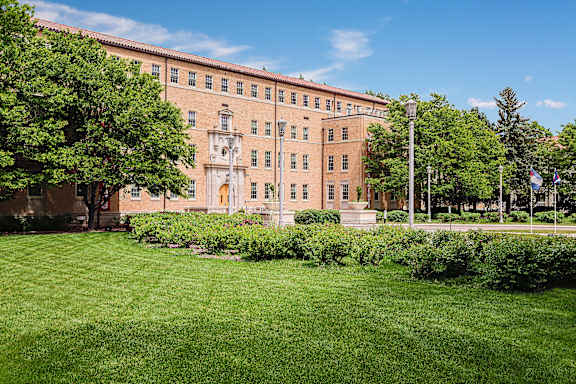 A large building with a green lawn in front.