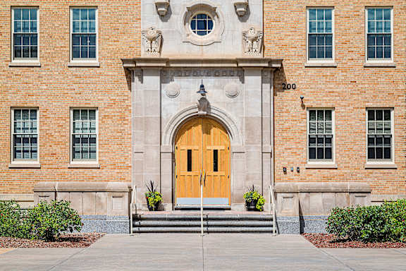 A large building with a yellow door and windows on the side.