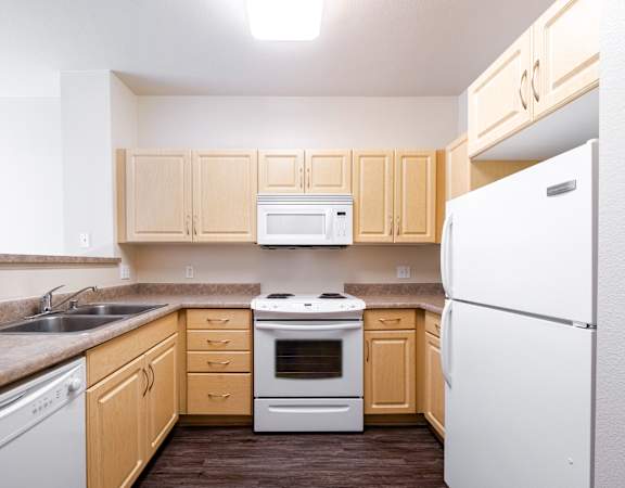 a kitchen with white appliances and wooden cabinets
