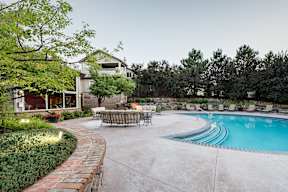 A backyard with a pool and a patio table.