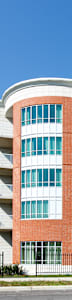a red and white apartment building with balconies on a sunny day