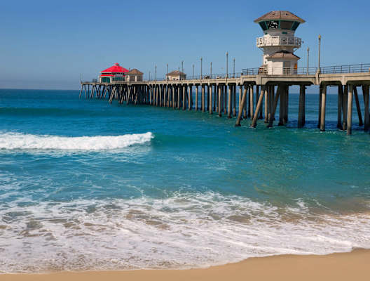 a pier with a beach and the ocean next to it