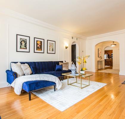 A living room with a blue couch and a coffee table.