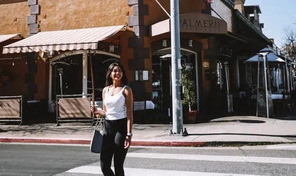 a woman crossing the street on a cross walk