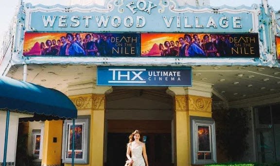 a bride standing outside of the westwood village theater