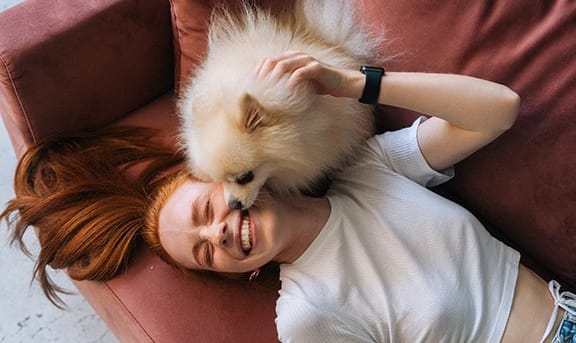 a woman laying on a couch with her dog