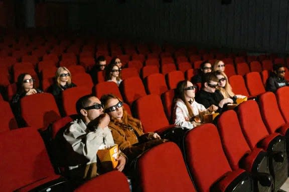people wearing 3d glasses sitting in a movie theater