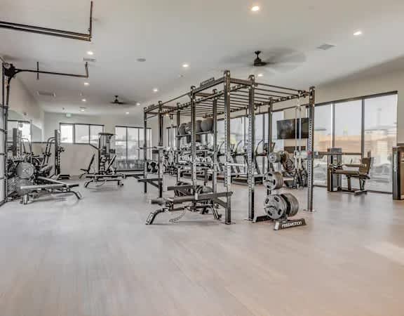 A spacious gym with a variety of equipment and a large mirror on the wall.