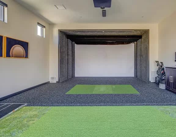 A room with a green carpet and a statue.