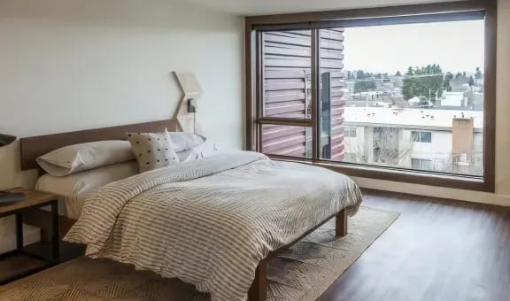 a bedroom with a bed and a large window