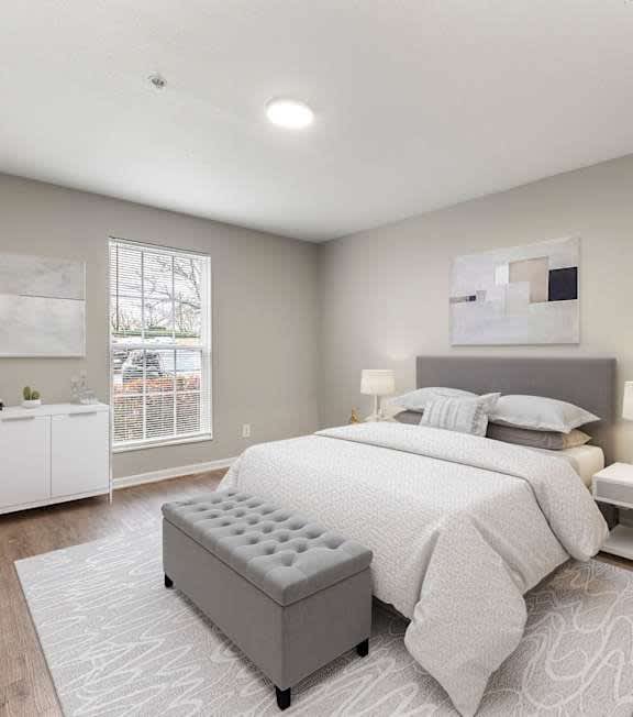 A bedroom with a large bed and a bench in front of it.
