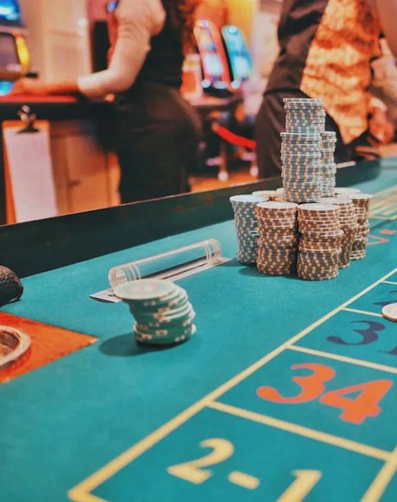 A casino table with a stack of poker chips and a roulette ball on it.