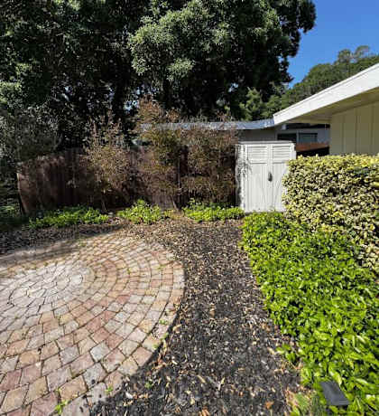 a brick path leading to a house with a white door
