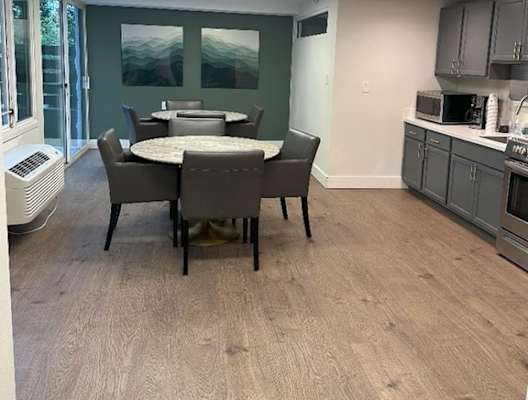 A dining room with a table and chairs.