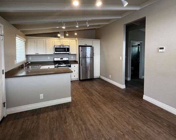 an empty kitchen with a stove and a refrigerator