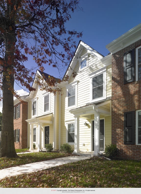 a row of town homes with white siding and brick