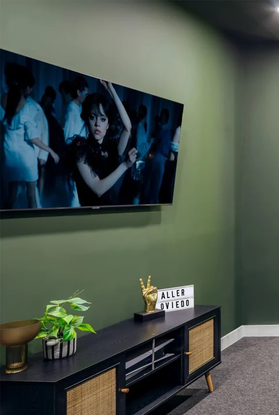 a living room with a tv on a green wall