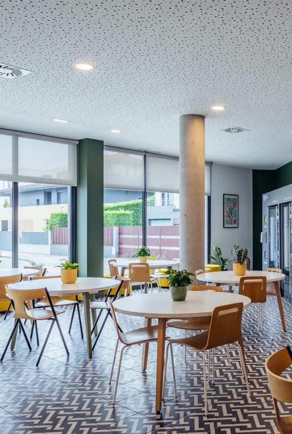 a dining room with tables and chairs and large windows
