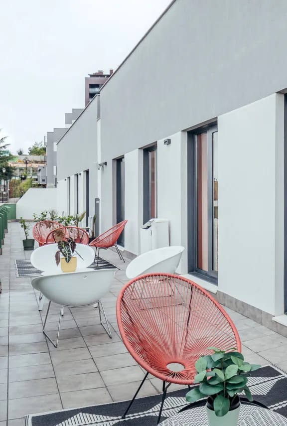 a terrace with tables and chairs and a umbrella