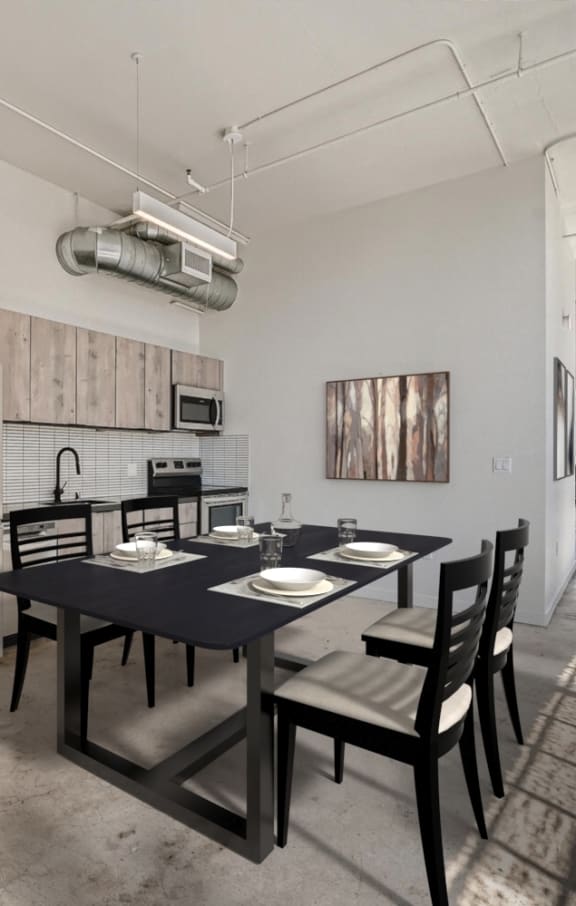 A dining room with a black table and chairs.