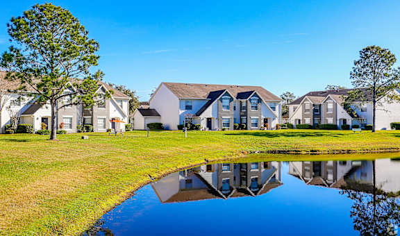 A row of houses with a pond in front.