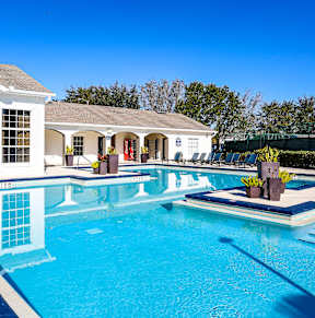 A swimming pool with a house in the background.