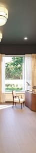 A spacious waiting room with a large mirror and comfortable seating.