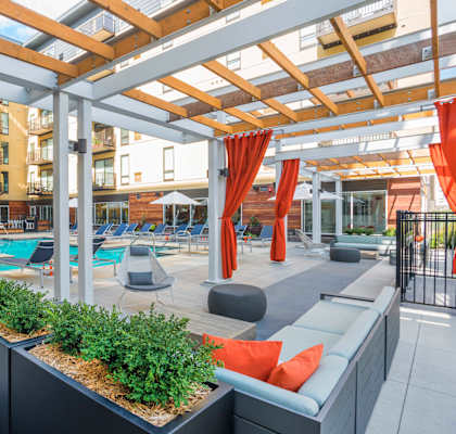 a communal area with couches and plants in front of an apartment building