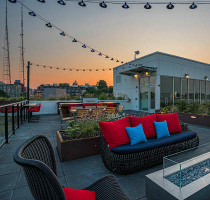 a rooftop patio with furniture and a building in the background