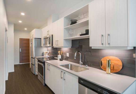 a kitchen with white cabinets and stainless steel appliances