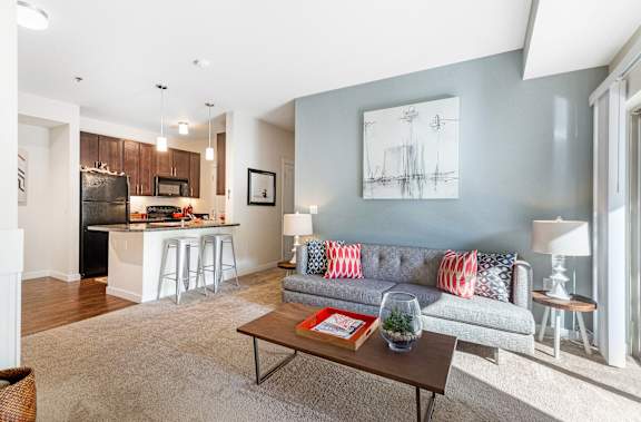 a living room with a couch and a coffee table in front of a kitchen